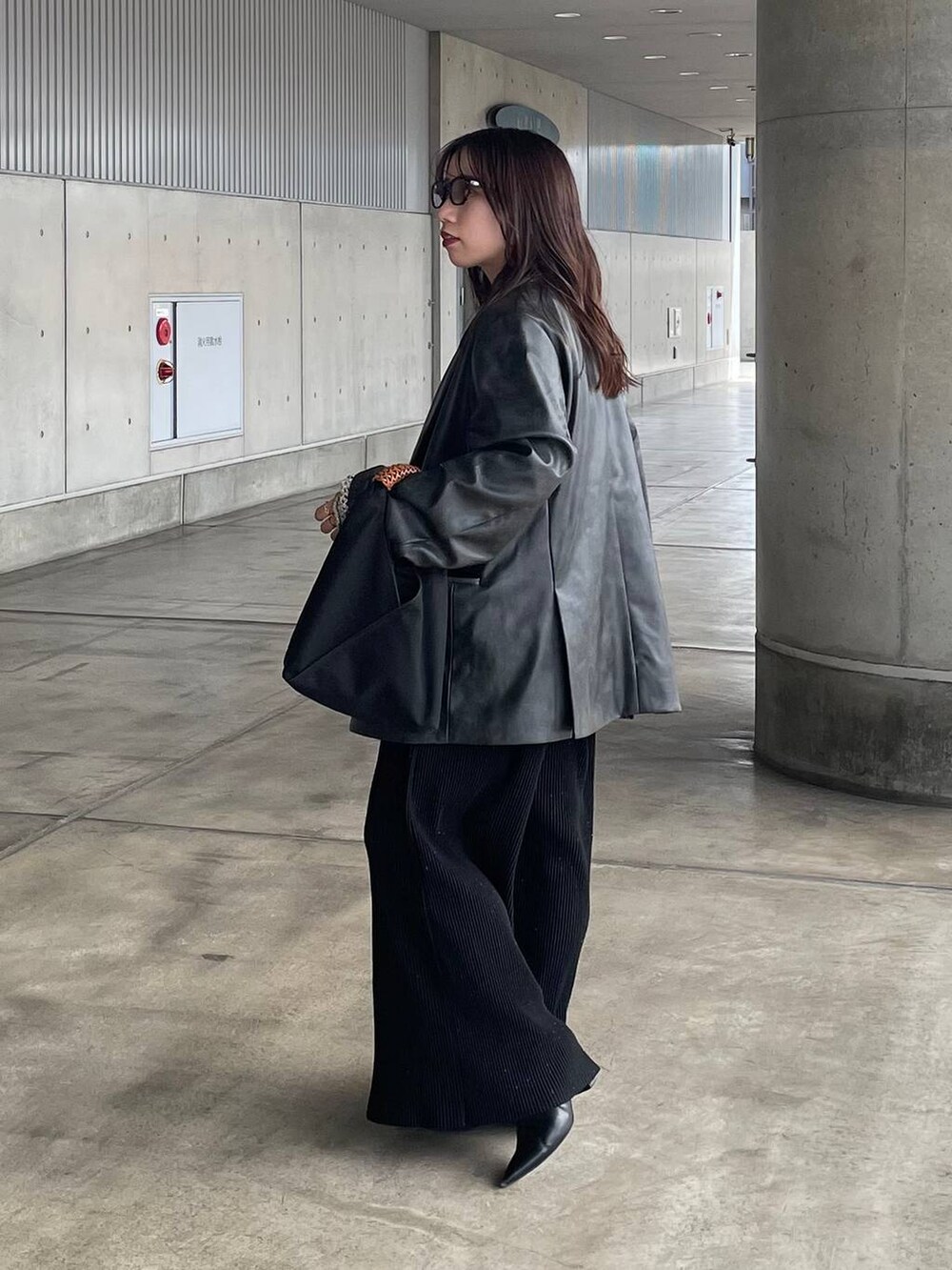 グレー系のテーラードジャケット、ブラック系のその他パンツを着用したレディースの秋コーディネートの2枚目の写真