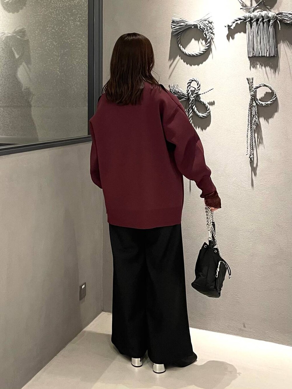 ブラック系のショルダーバッグ、ブラック系のブーツ、レッド系のTシャツ/カットソーを着用したレディースの秋コーディネートの2枚目の写真