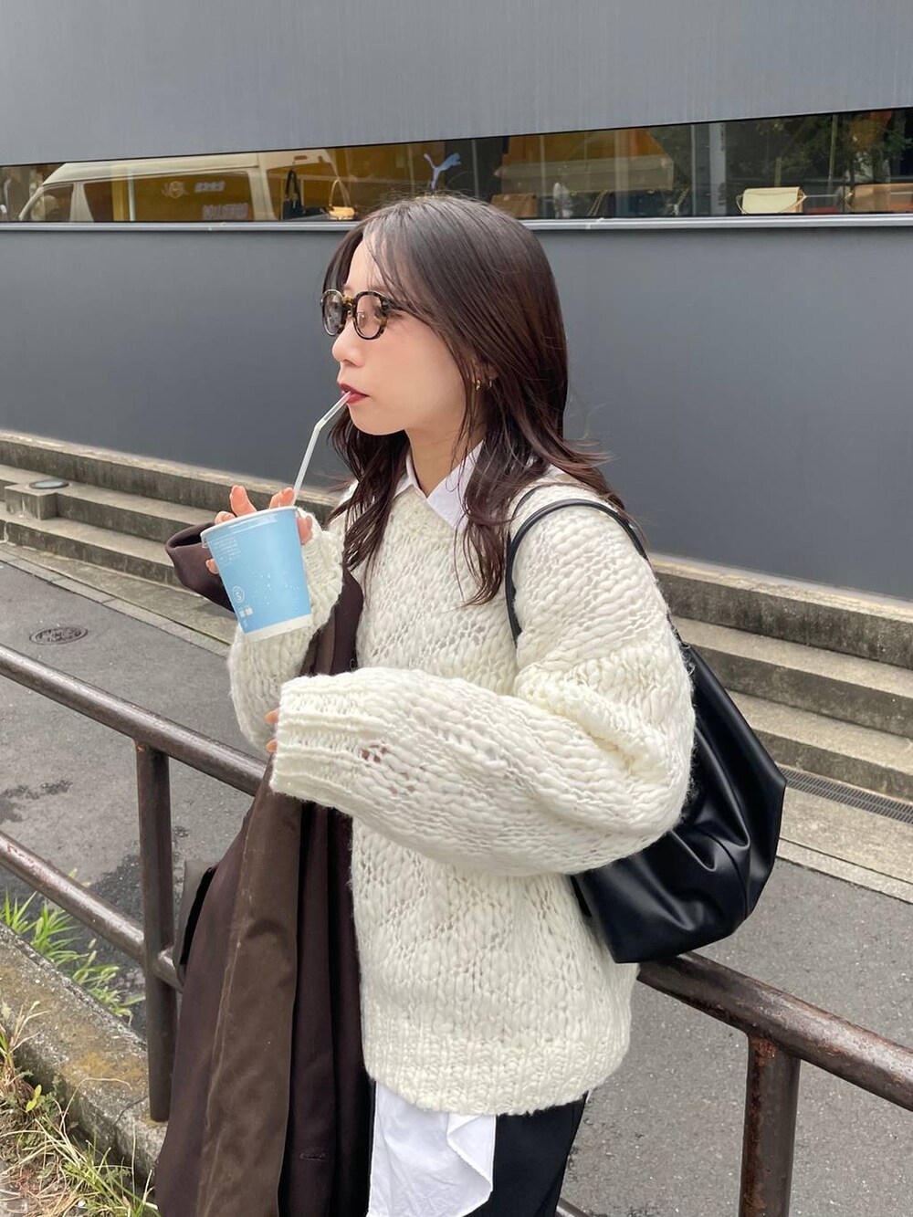 ブラック系のショルダーバッグ、ホワイト系のニット/セーターを着用したレディースの秋コーディネートの3枚目の写真