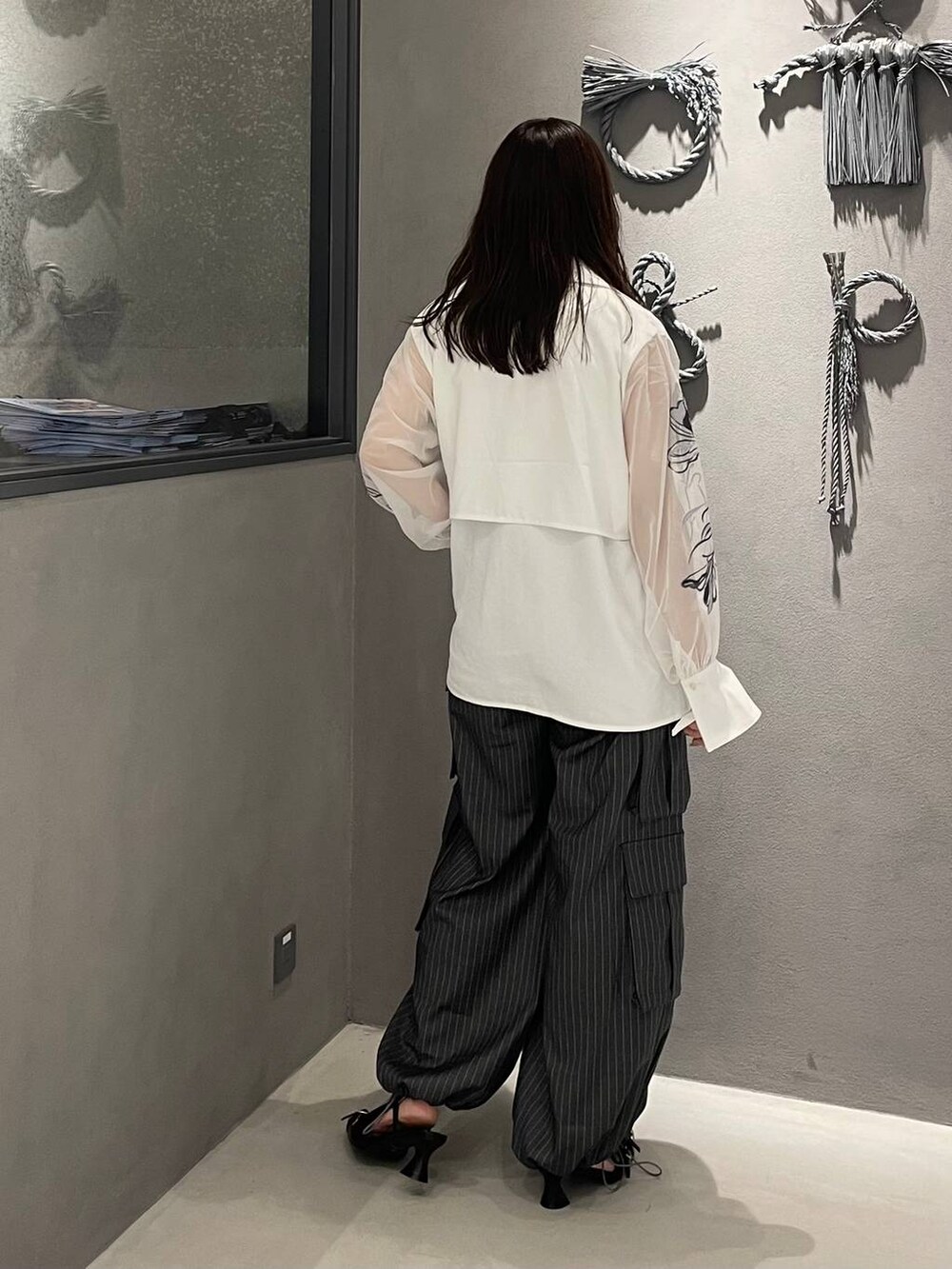 ホワイト系のタンクトップ、ホワイト系のシャツ/ブラウス、ブラック系のパンプスを着用したレディースの夏コーディネートの3枚目の写真