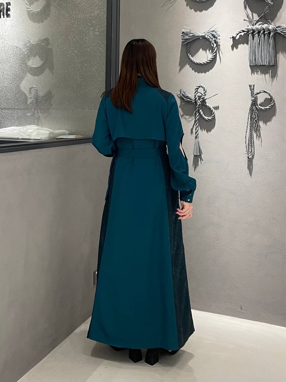 グリーン系のワンピース、ブラック系のサンダルを着用したレディースの春コーディネートの2枚目の写真