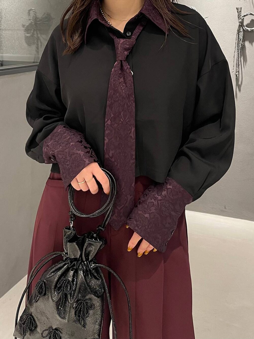 ブラック系のパンプス、ブラック系のショルダーバッグ、パープル系のシャツ/ブラウスを着用したレディースの夏コーディネートの5枚目の写真