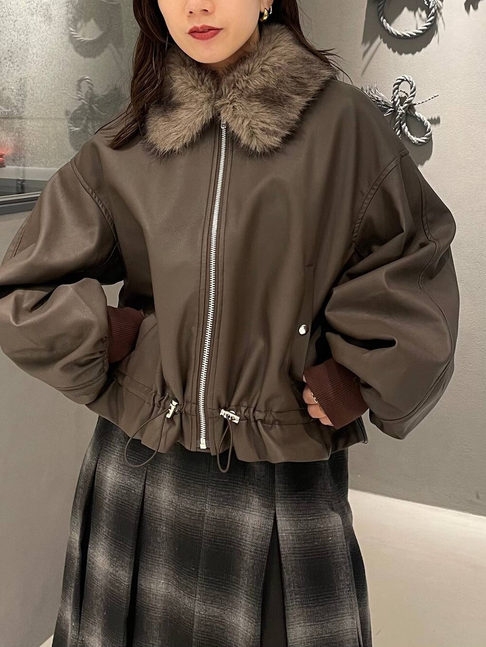 レッド系のニット/セーター、ブラック系のブーツ、ブラウン系のブルゾンを着用したレディースの秋コーディネートの4枚目の写真