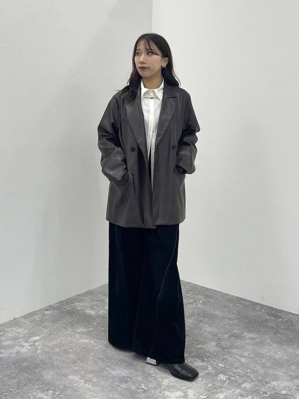 ブラウン系のテーラードジャケット、ブラック系のブーツ、ホワイト系のシャツ/ブラウスを着用したレディースの秋コーディネートの2枚目の写真