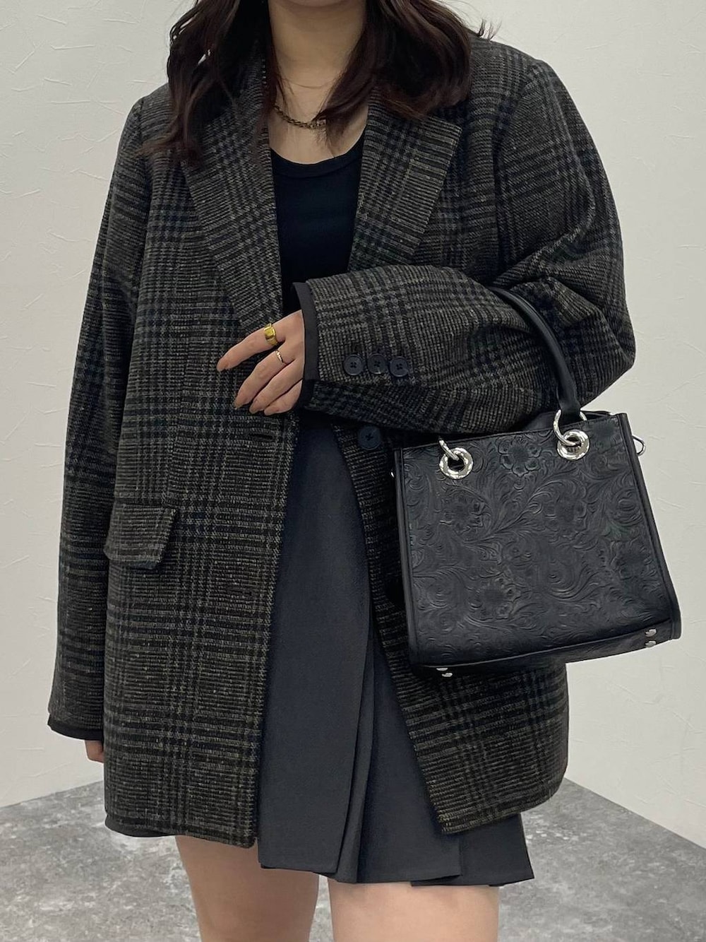 ブラック系のTシャツ/カットソー、ブラック系のショルダーバッグ、ブラック系のブーツを着用したレディースの秋コーディネートの4枚目の写真