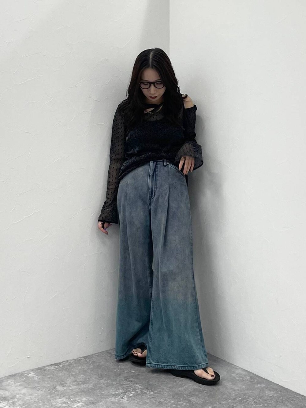 ブラック系のキャミソール、ブルー系のデニムパンツ、ブラック系のサンダルを着用したレディースの夏コーディネートの8枚目の写真