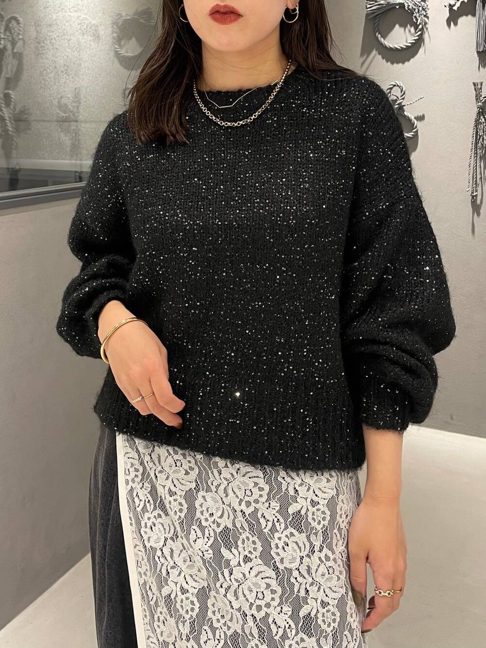 ブラック系のパンプス、ブラック系のニット/セーター、ブラック系のデニムパンツを着用したレディースの秋コーディネートの4枚目の写真