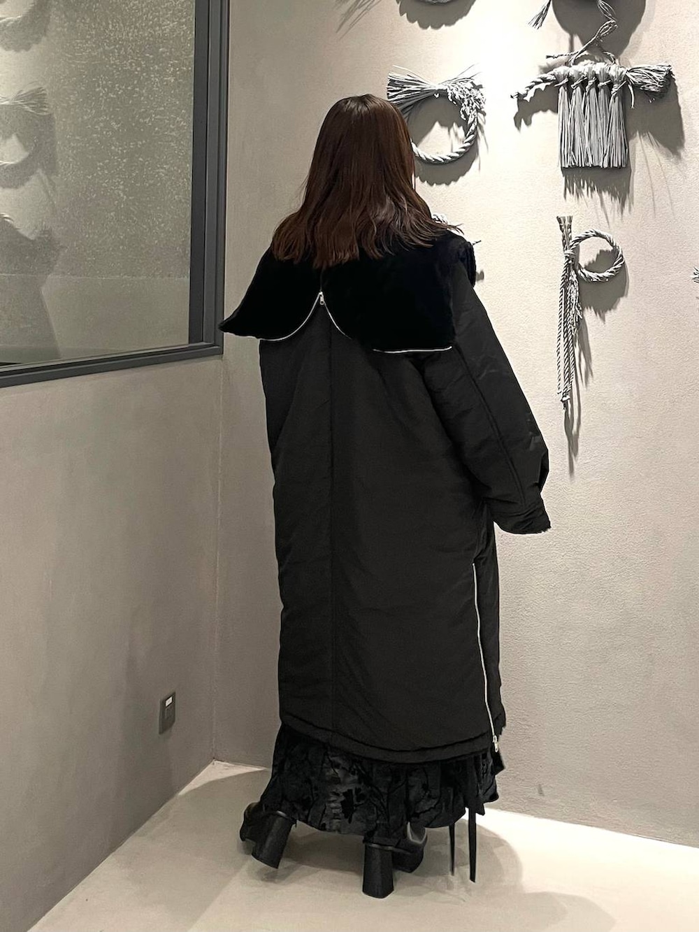 ブラック系のダウンジャケット/コート、ブラック系のブーツ、ブラック系のニット/セーターを着用したレディースの秋コーディネートの3枚目の写真