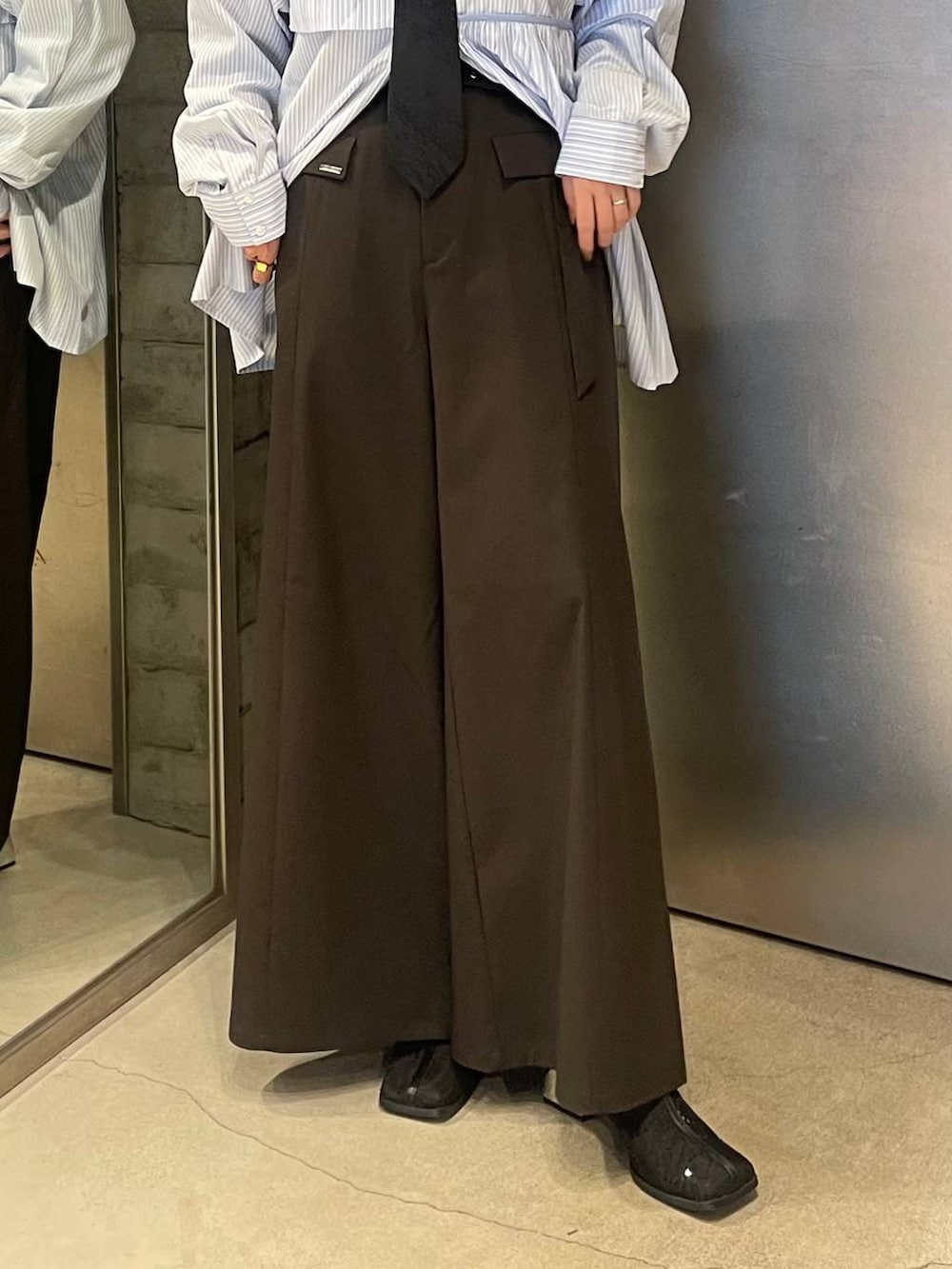 ブラック系のネクタイ、ブラック系のブーツ、ブルー系のシャツ/ブラウスを着用したレディースの春コーディネートの5枚目の写真