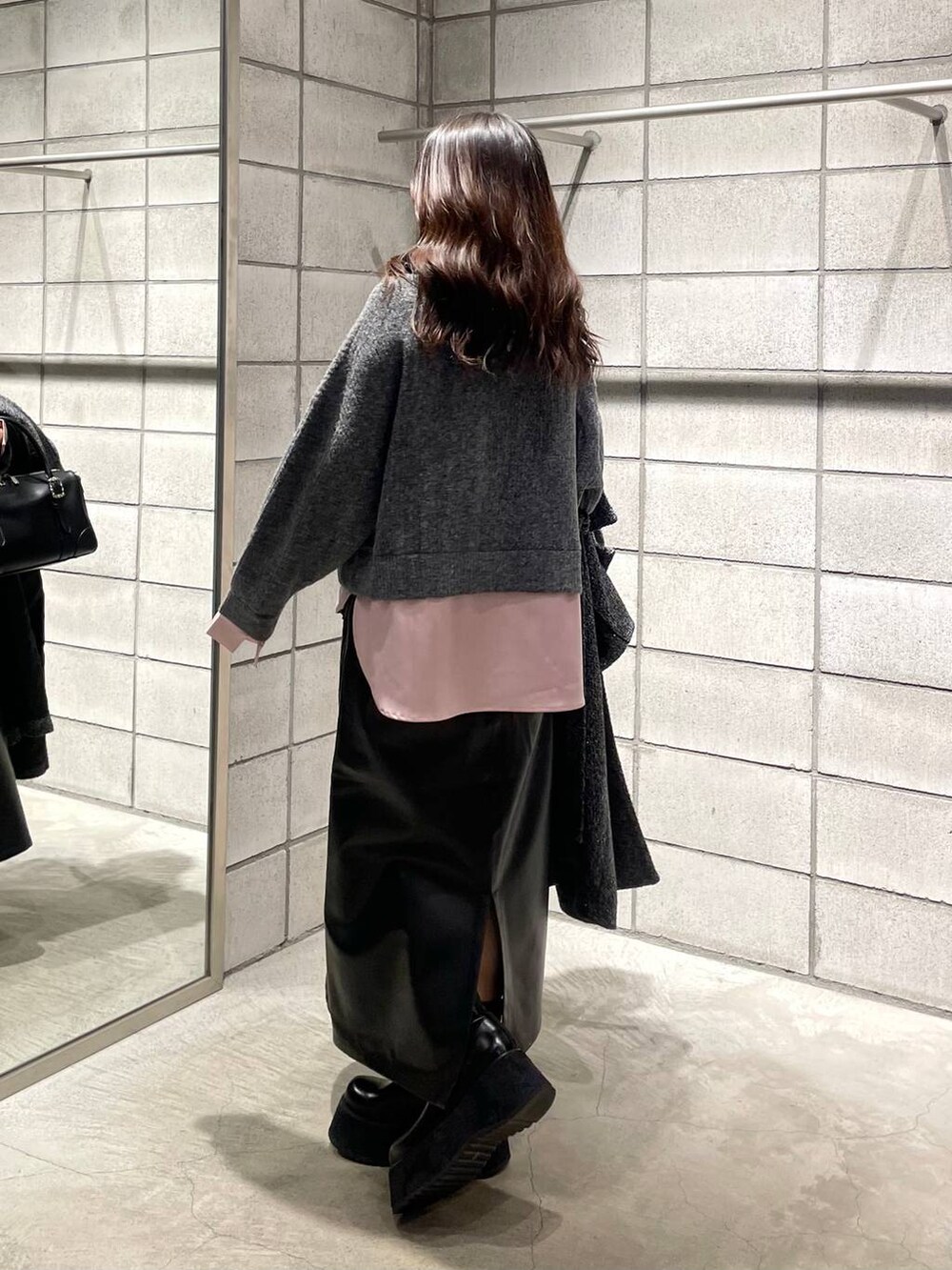 ブラック系のボストンバッグ、ピンク系のニット/セーター、ブラック系のブーツを着用したレディースの冬コーディネートの4枚目の写真