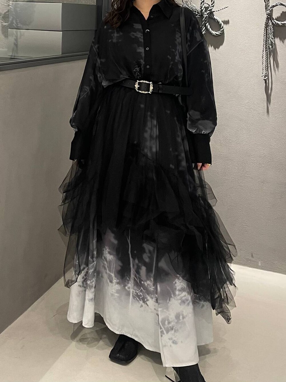 ブラック系のブーツ、ブラック系のショルダーバッグ、ブラック系のスカートを着用したレディースの冬コーディネートの5枚目の写真