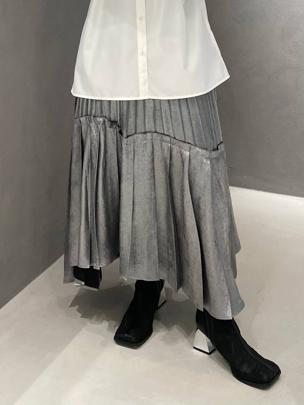 ブラック系のブーツ、ホワイト系のシャツ/ブラウス、シルバー系のスカートを着用したレディースの春コーディネートの6枚目の写真