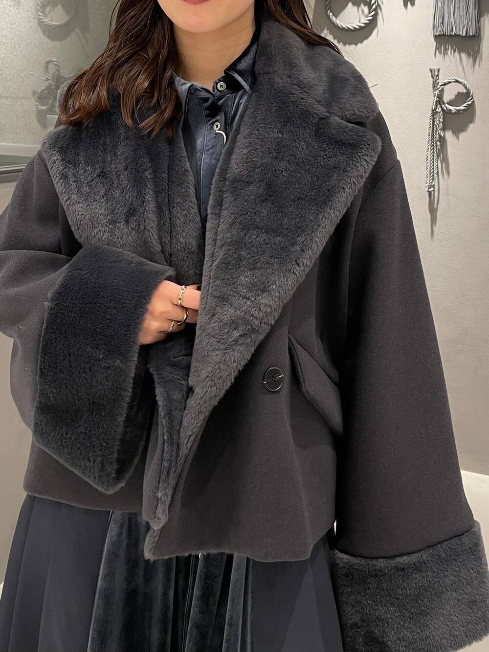 ブルー系のワンピース、ブラック系のブーツ、グレー系のその他アウターを着用したレディースの冬コーディネートの6枚目の写真