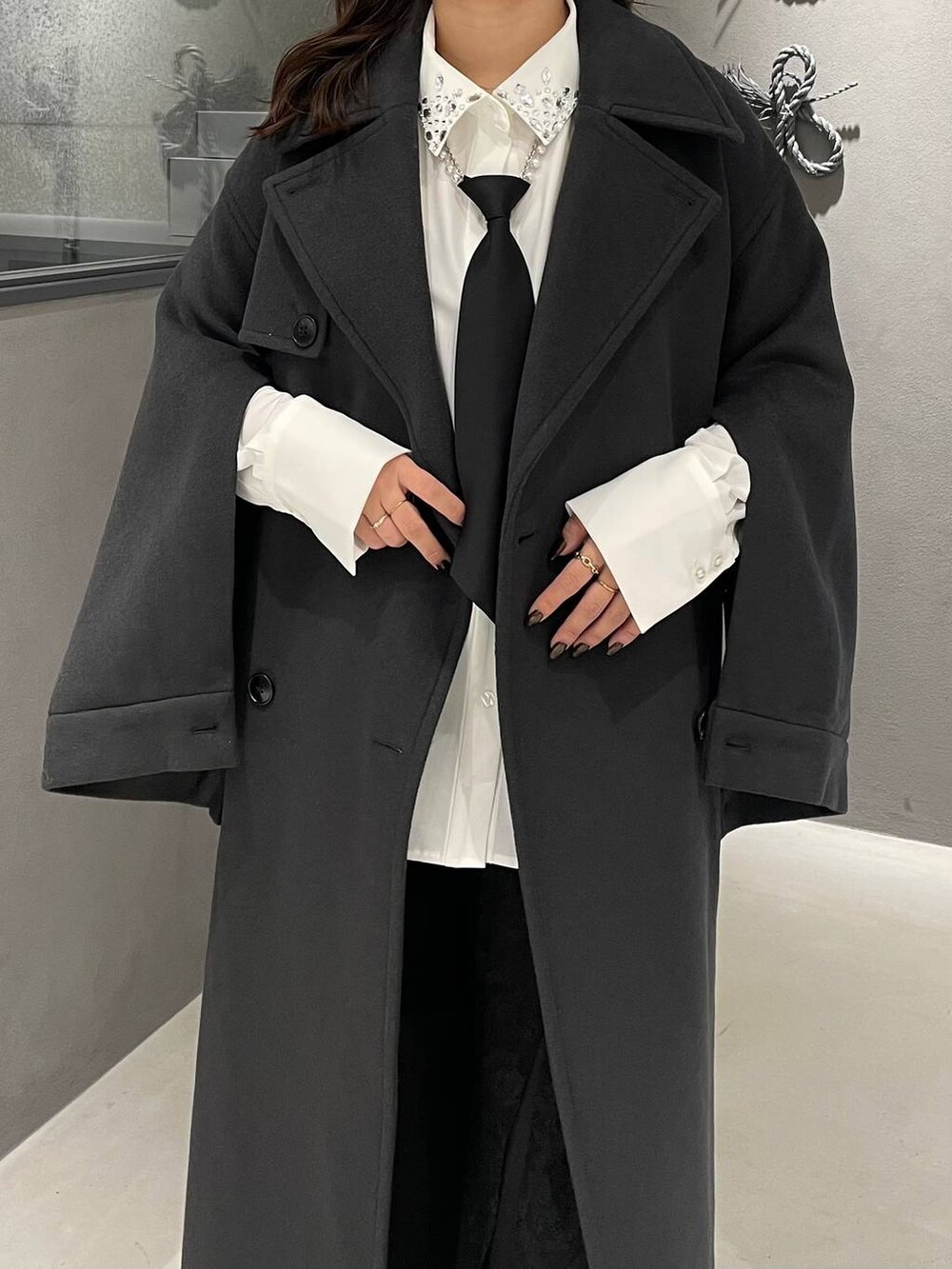 ブラック系のネクタイ、ホワイト系のシャツ/ブラウス、ブラック系のブーツを着用したレディースの冬コーディネートの4枚目の写真