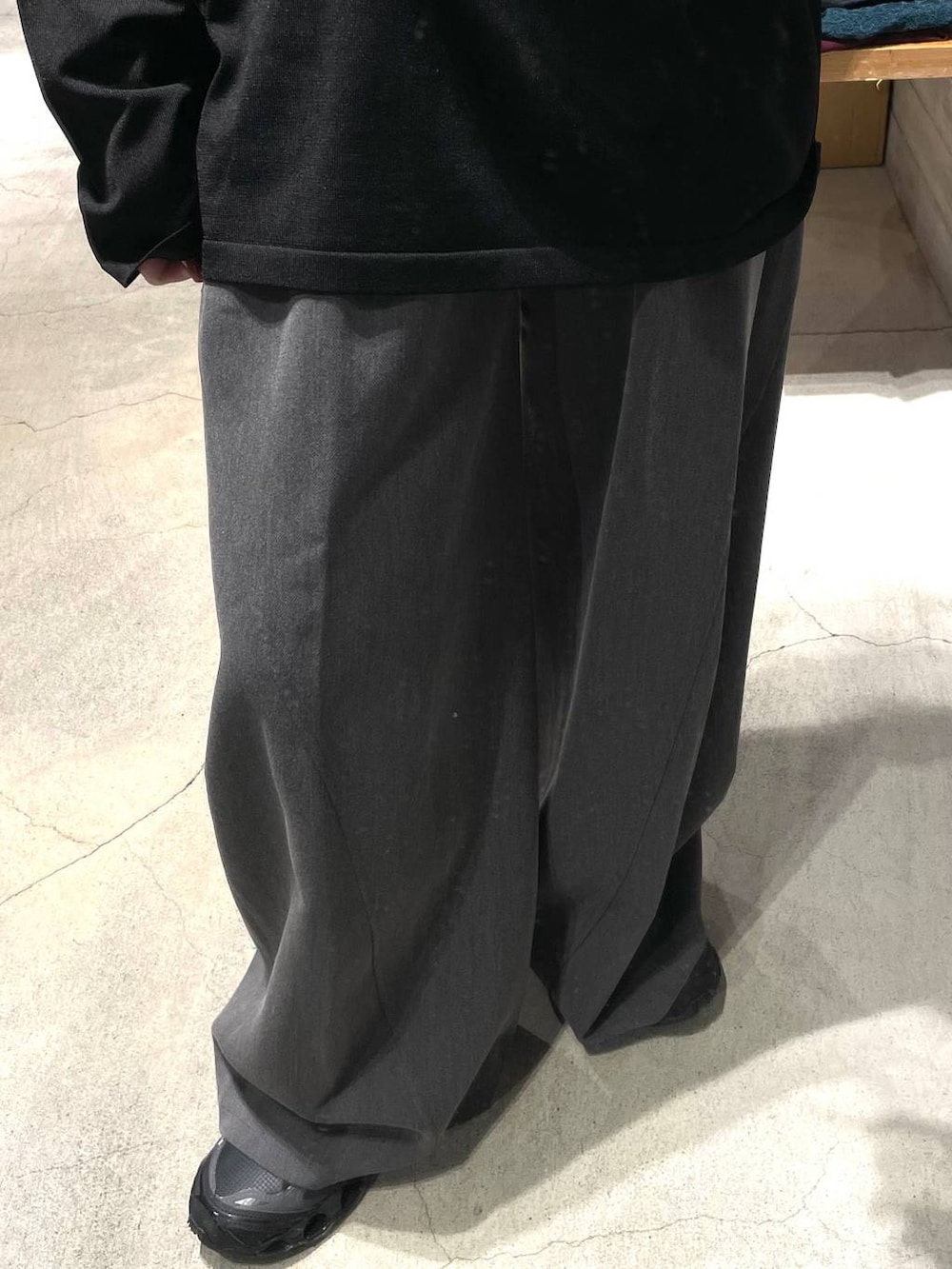 グレー系のスラックス、ブラック系のニット/セーターを着用したレディースの秋コーディネートの3枚目の写真