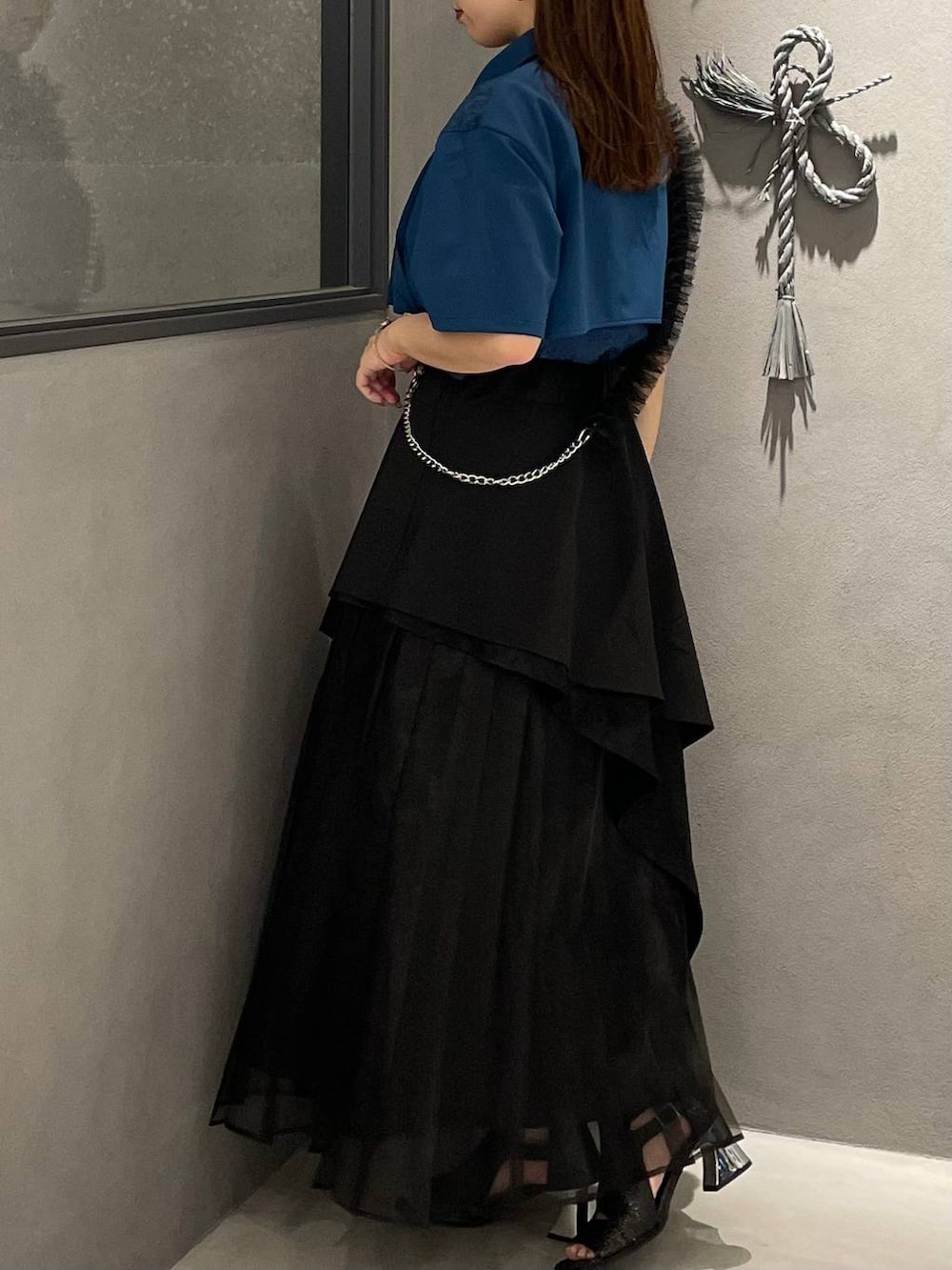 ブルー系のシャツ/ブラウス、ブラック系のスカート、ブラック系のサンダルを着用したレディースの春コーディネートの3枚目の写真