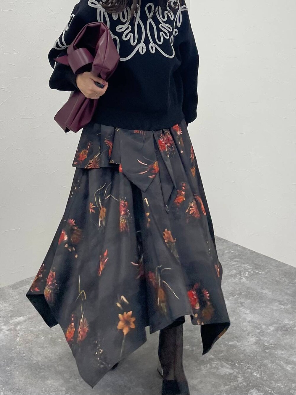 レッド系のトートバッグ、ブラック系のブーツ、ブラック系のニット/セーターを着用したレディースの夏コーディネートの6枚目の写真