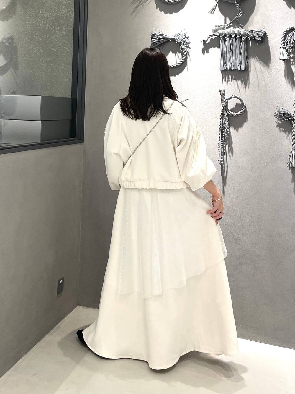 ブラック系のブーツ、ホワイト系のスカート、ホワイト系のブルゾンを着用したレディースの冬コーディネートの3枚目の写真