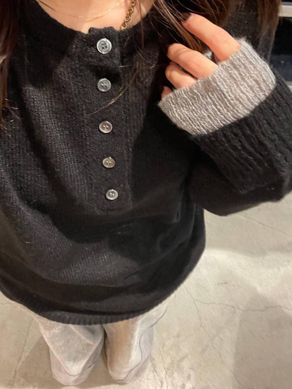 ブラック系のニット/セーター、グレー系のデニムパンツを着用したレディースの秋コーディネートの3枚目の写真