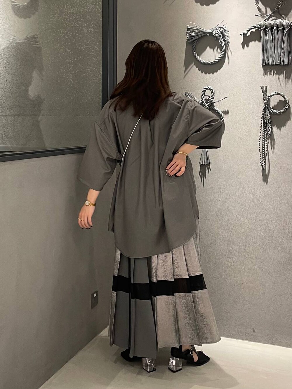グレー系のスカート、グレー系のシャツ/ブラウス、ブラック系のサンダルを着用したレディースの春コーディネートの3枚目の写真