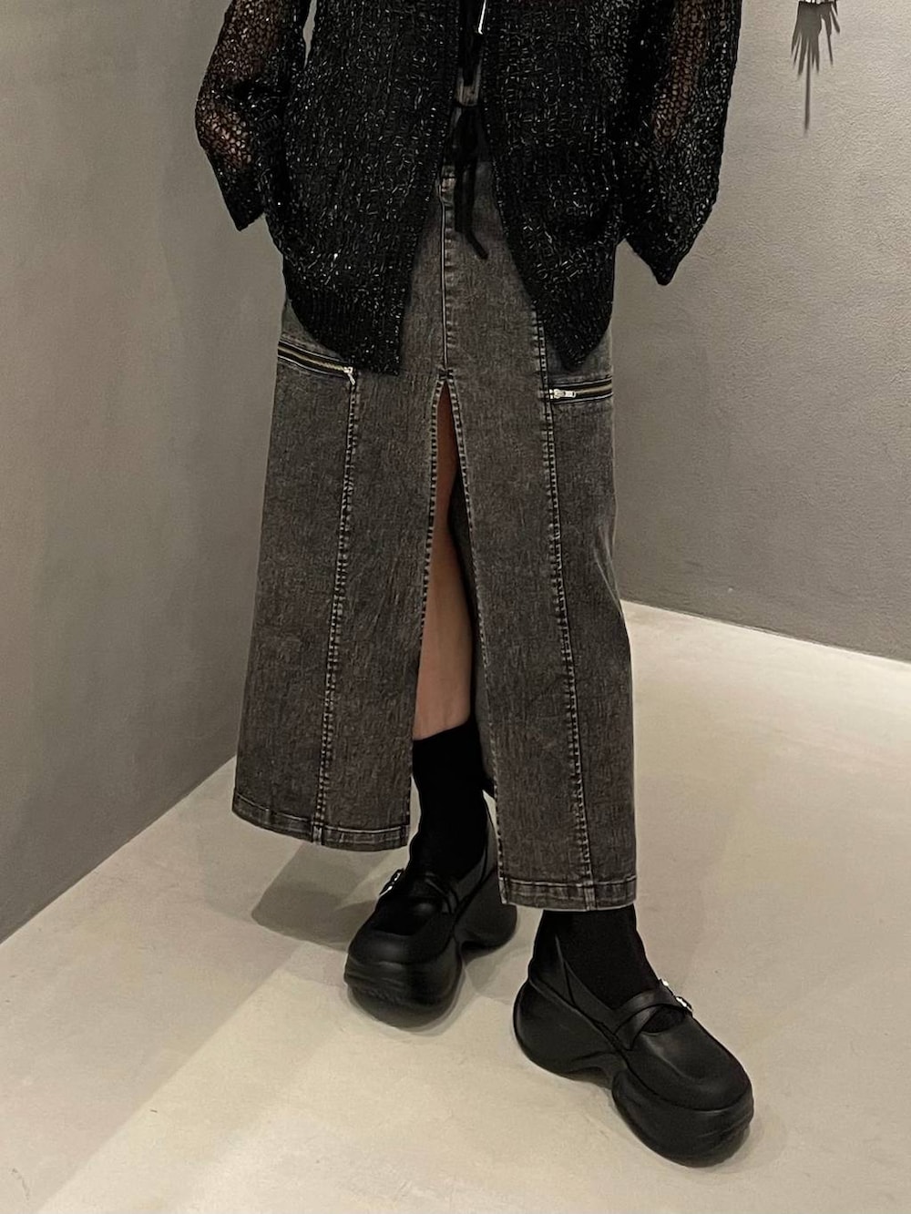 ブラック系のブーツ、ブラック系のニット/セーター、ブラック系のスカートを着用したレディースの夏コーディネートの5枚目の写真