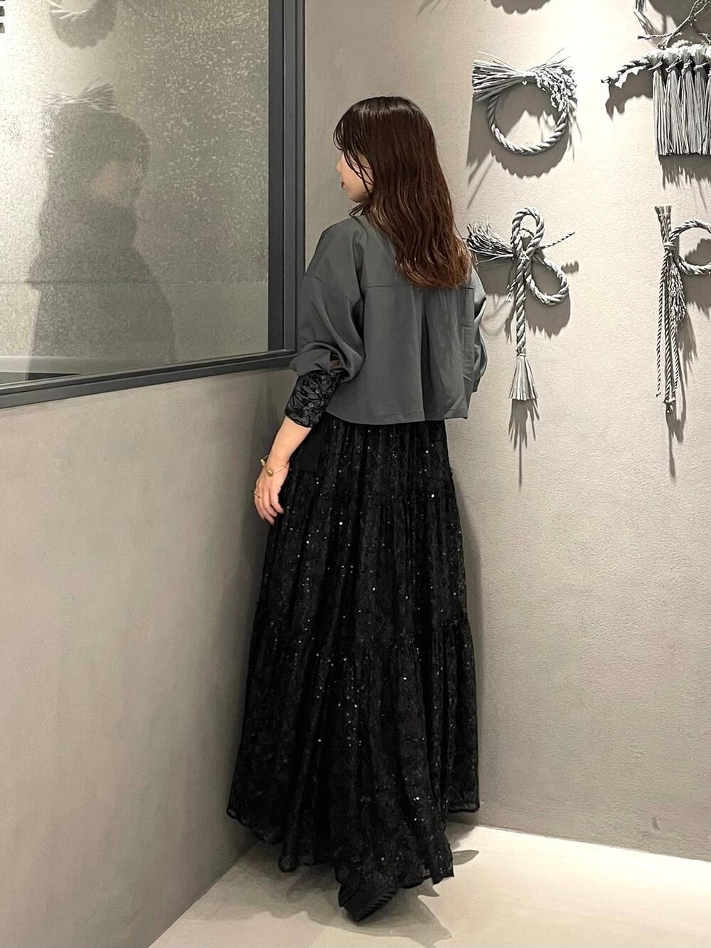 ブラック系のブーツ、グレー系のシャツ/ブラウス、ブラック系のスカートを着用したレディースの秋コーディネートの2枚目の写真