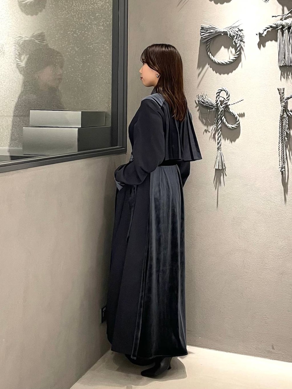 ブルー系のワンピース、ブラック系のブーツを着用したレディースの冬コーディネートの2枚目の写真