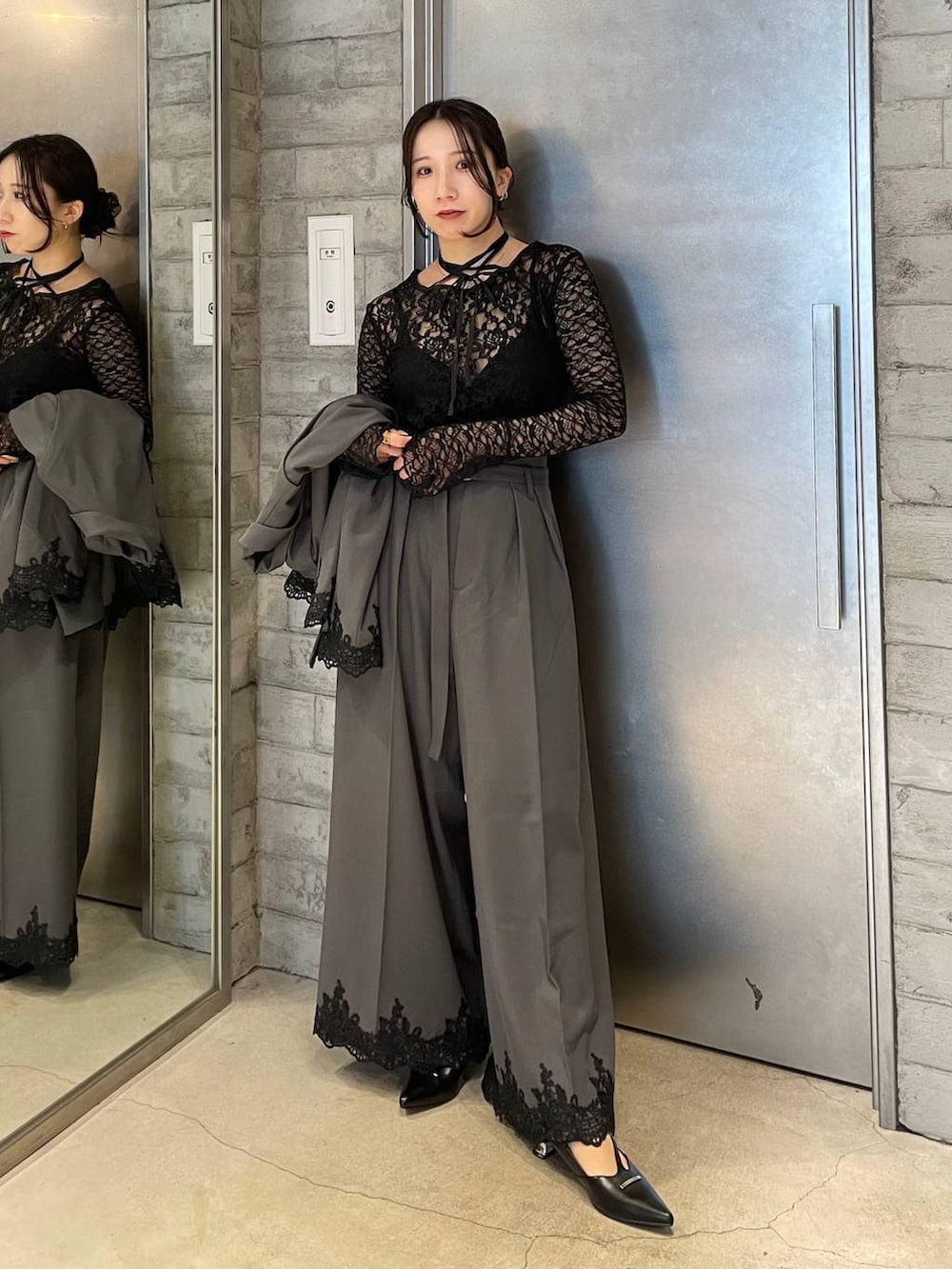 ブラック系のパンプス、グレー系のスラックス、ブラック系のTシャツ/カットソーを着用したレディースの冬コーディネートの2枚目の写真