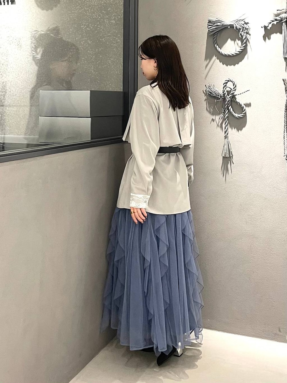 ブラック系のブーツ、ホワイト系のシャツ/ブラウス、ブルー系のスカートを着用したレディースの冬コーディネートの2枚目の写真