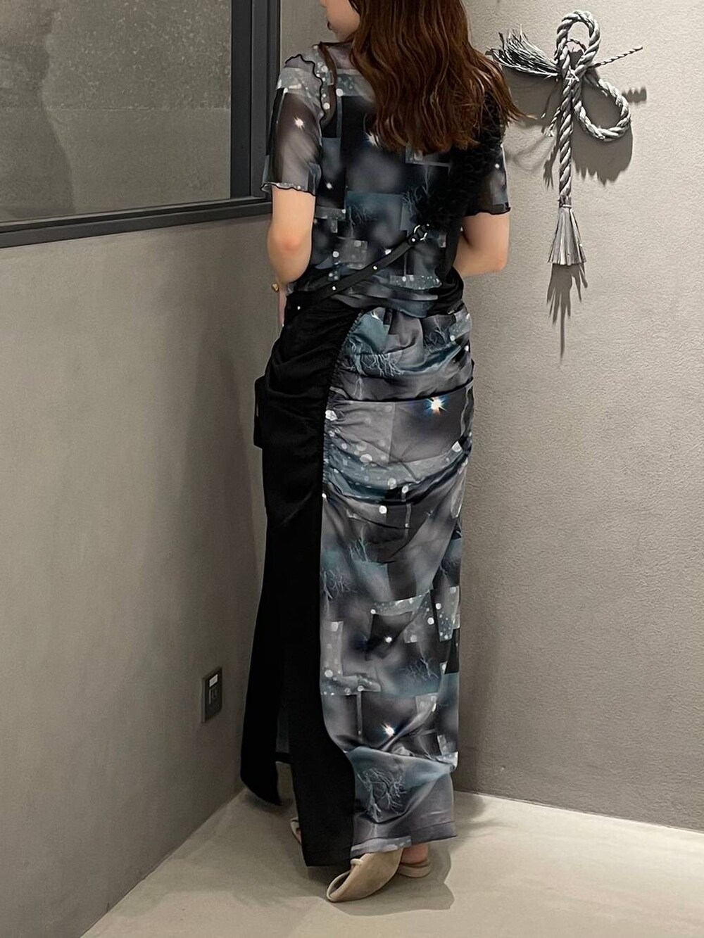 ホワイト系のサンダル、ブラック系のTシャツ/カットソー、ブラック系のスカートを着用したレディースの夏コーディネートの3枚目の写真