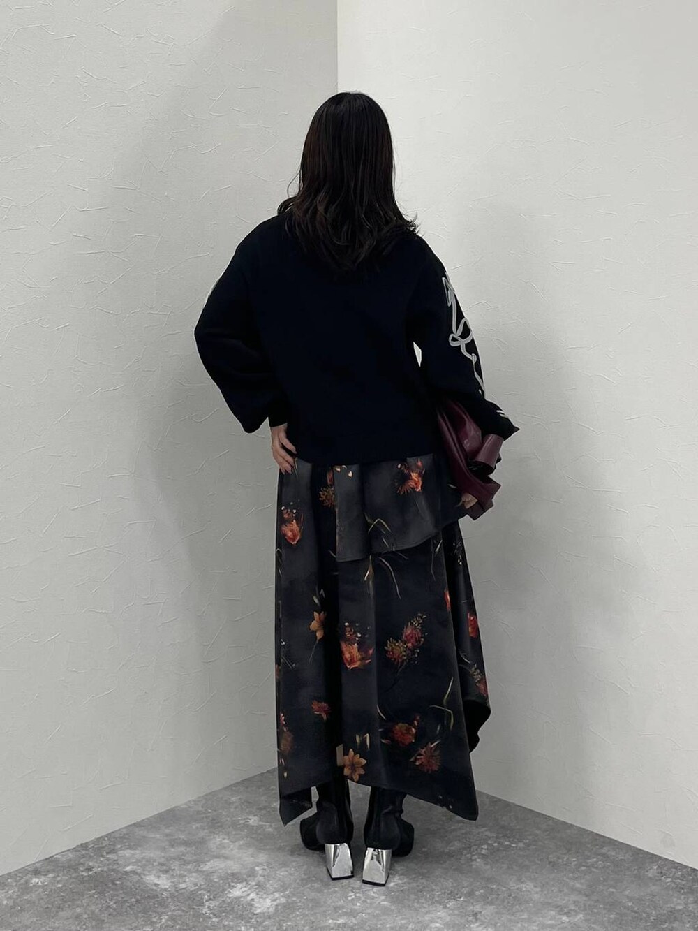 レッド系のトートバッグ、ブラック系のブーツ、ブラック系のニット/セーターを着用したレディースの夏コーディネートの3枚目の写真