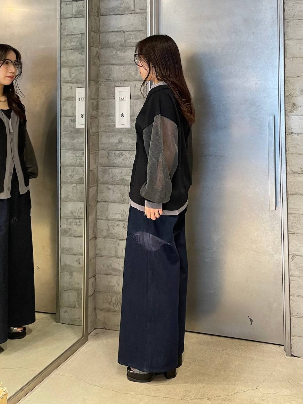 シルバー系のブーツ、ブルー系のデニムパンツ、ブラック系のカーディガン/ボレロを着用したレディースの春コーディネートの2枚目の写真