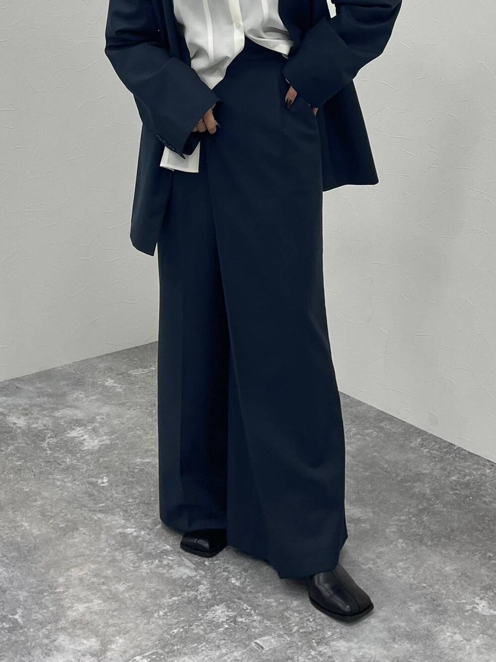 ブラック系のブーツ、ホワイト系のシャツ/ブラウス、グレー系のノーカラージャケットを着用したレディースの秋コーディネートの5枚目の写真