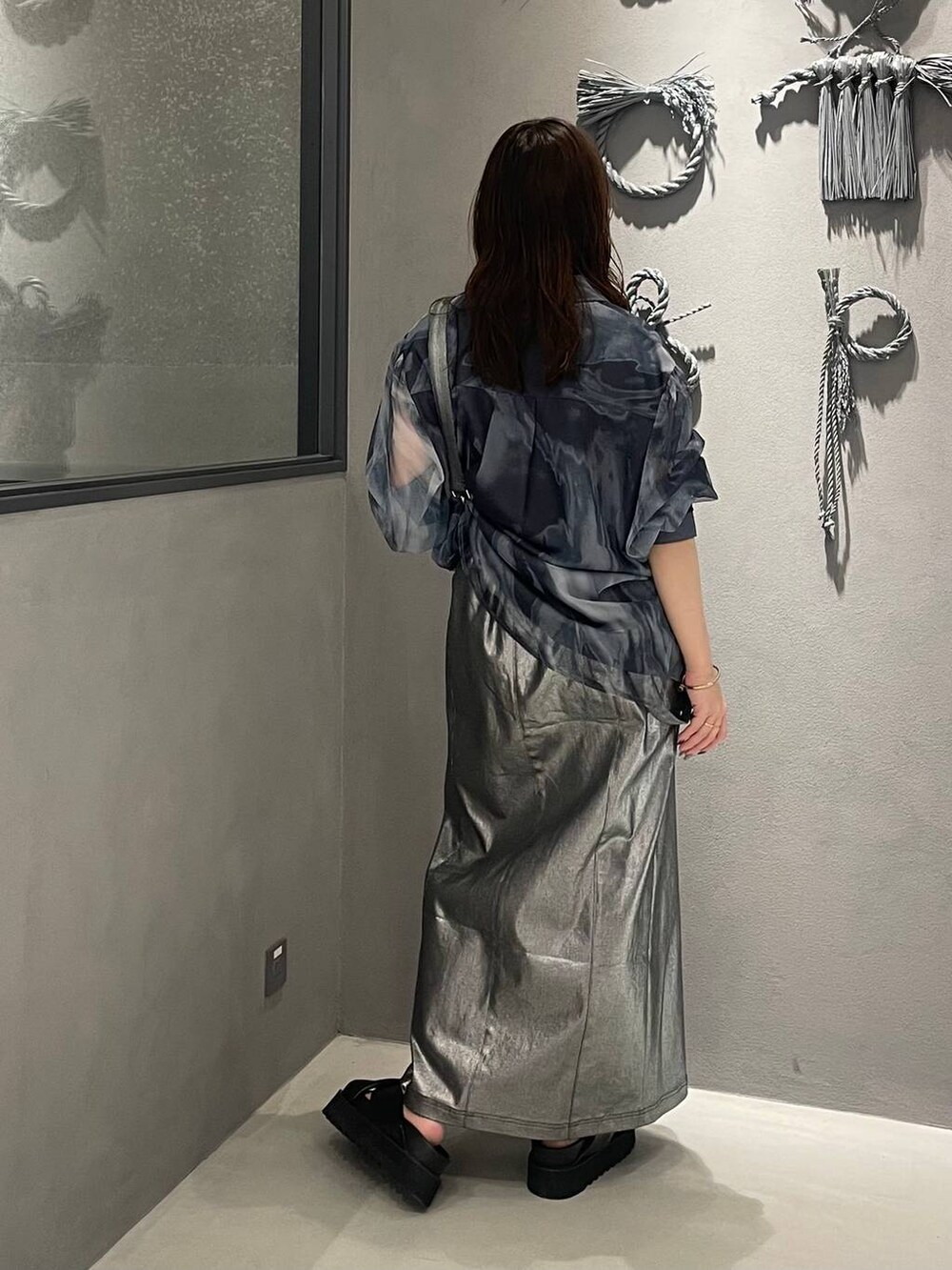 ブラック系のサンダル、シルバー系のスカートを着用したレディースの春コーディネートの3枚目の写真