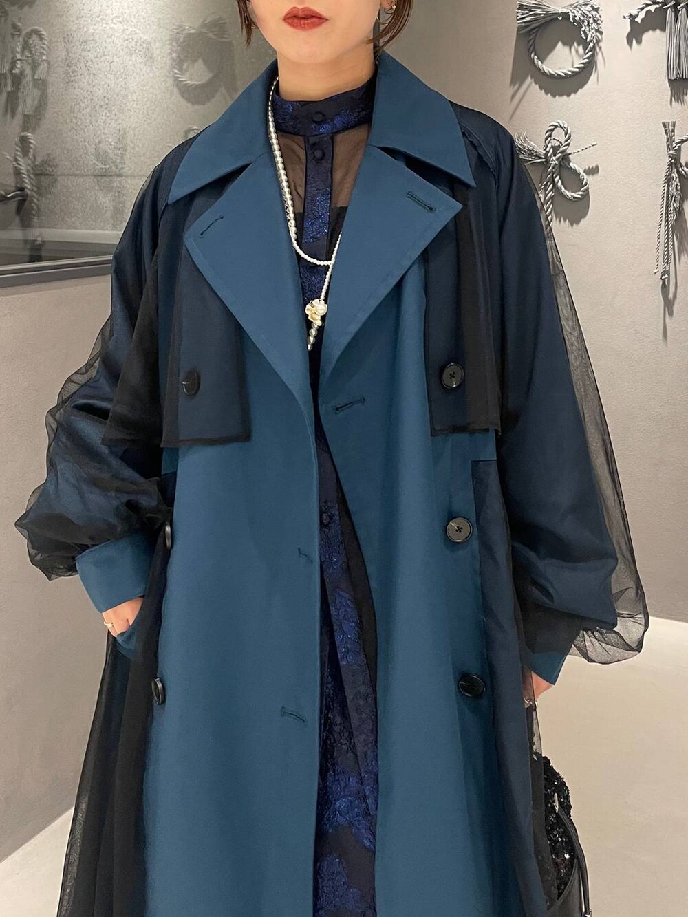 ホワイト系のサンダル、ブルー系のドレス、ブルー系のトレンチコートを着用したレディースの秋コーディネートの6枚目の写真