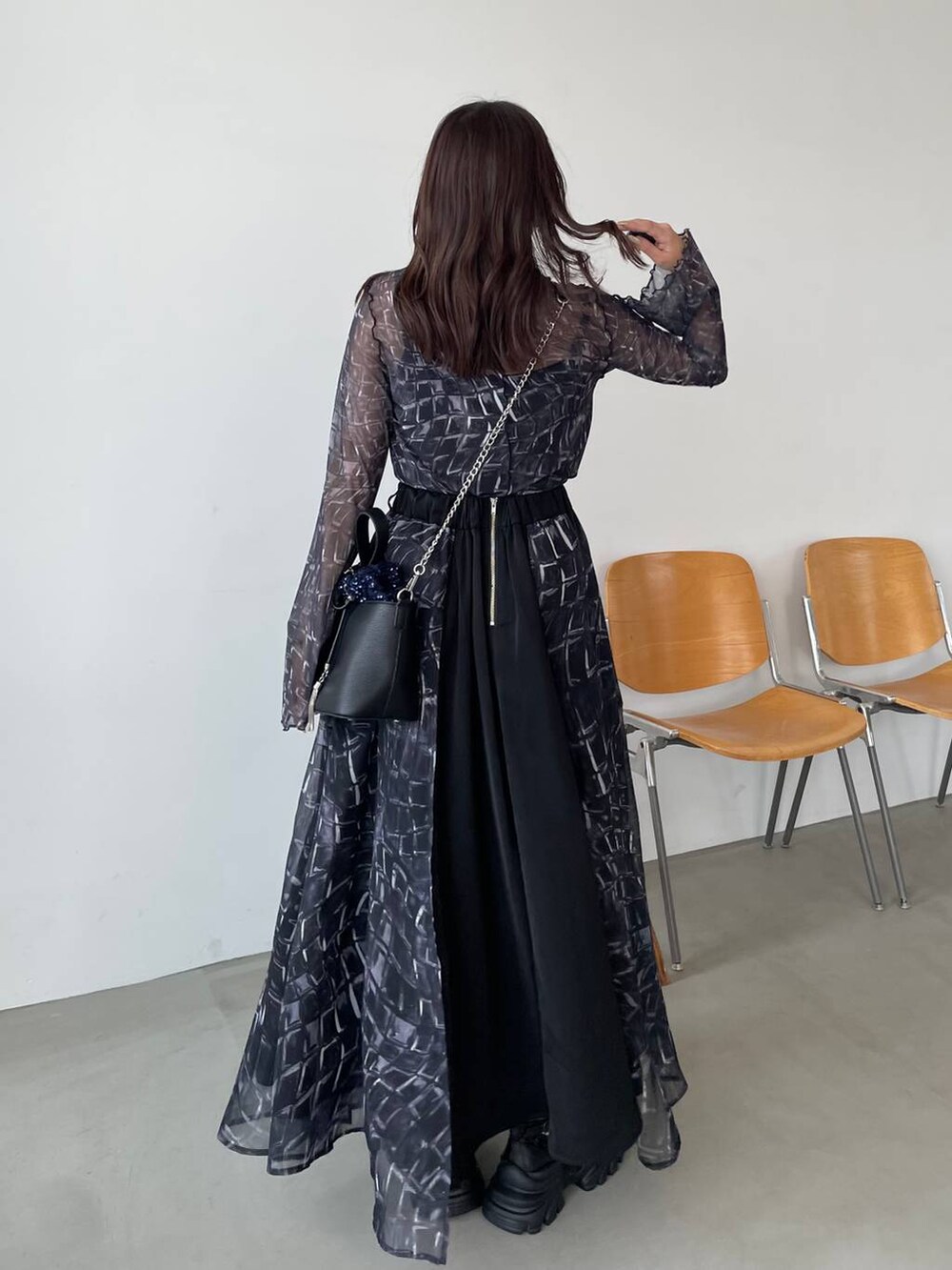 ブラック系のスニーカー、ブラック系のTシャツ/カットソー、ブルー系のショルダーバッグを着用したレディースの夏コーディネートの2枚目の写真