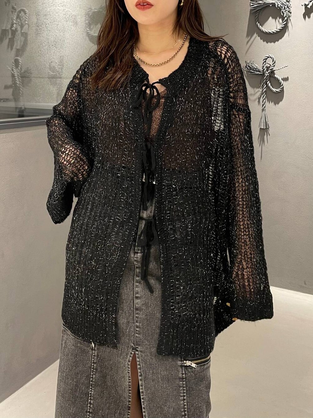 ブラック系のブーツ、ブラック系のニット/セーター、ブラック系のスカートを着用したレディースの夏コーディネートの4枚目の写真