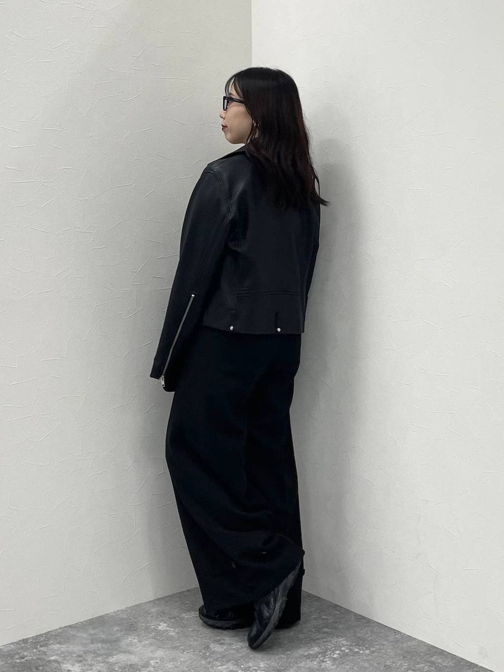 ブラック系のTシャツ/カットソー、ブラック系のライダースジャケット、ブラック系のスラックスを着用したレディースの秋コーディネートの2枚目の写真