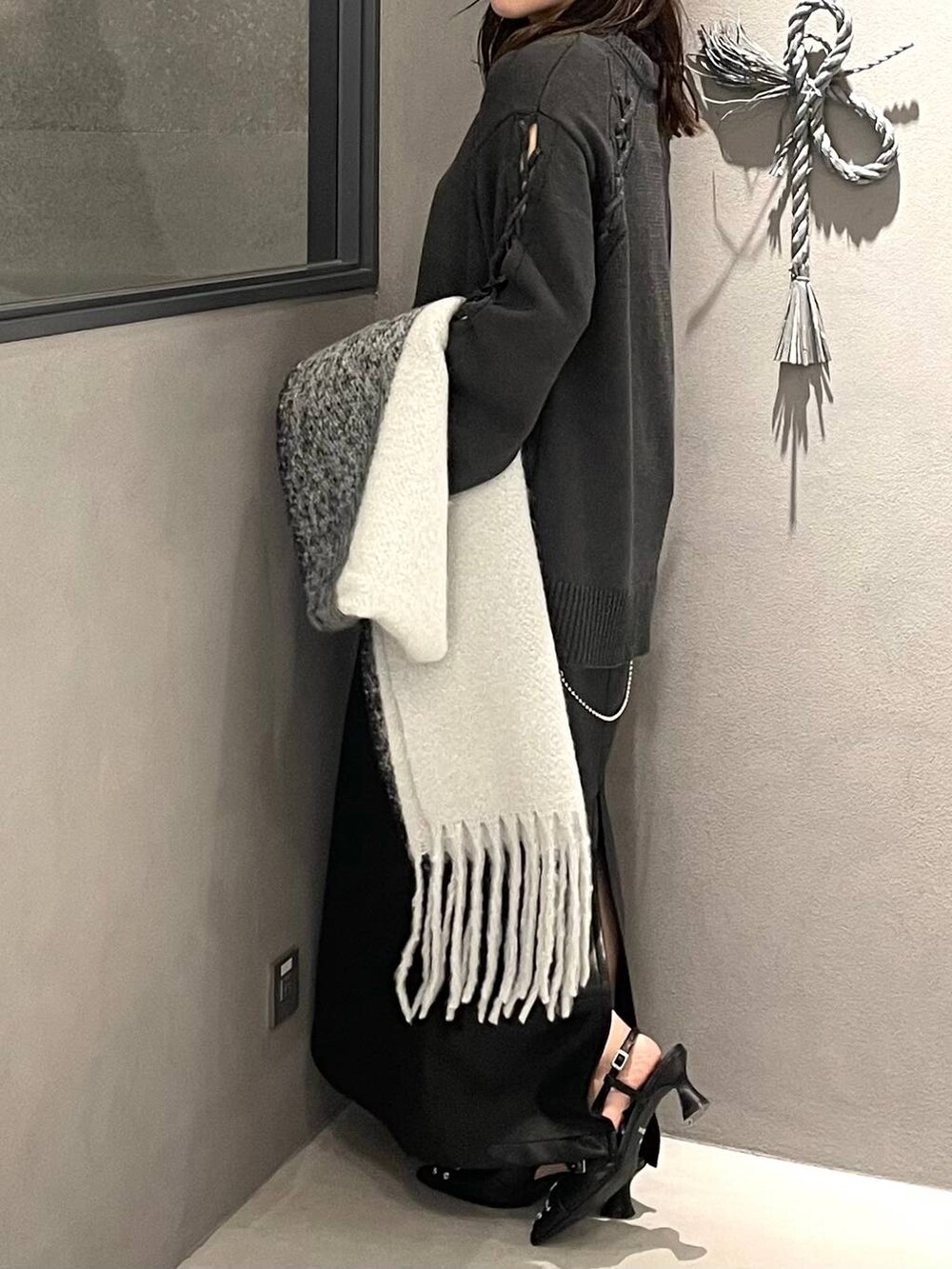 ブラック系のパンプス、グレー系のニット/セーター、ブラック系のスカートを着用したレディースの秋コーディネートの3枚目の写真