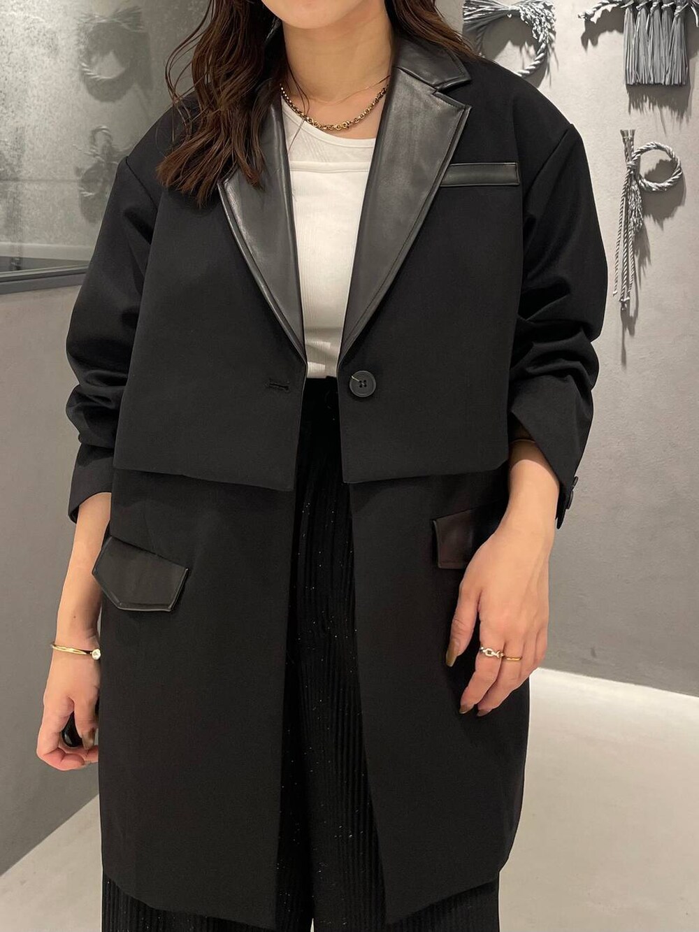 ホワイト系のタンクトップ、ブラック系のブーツ、ブラック系のその他パンツを着用したレディースの秋コーディネートの4枚目の写真