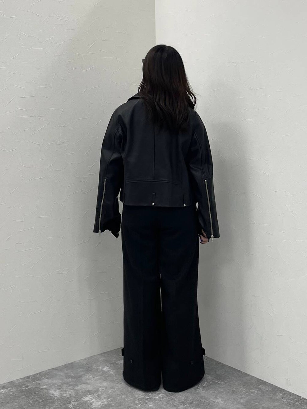 ブラック系のTシャツ/カットソー、ブラック系のライダースジャケット、ブラック系のスラックスを着用したレディースの秋コーディネートの3枚目の写真