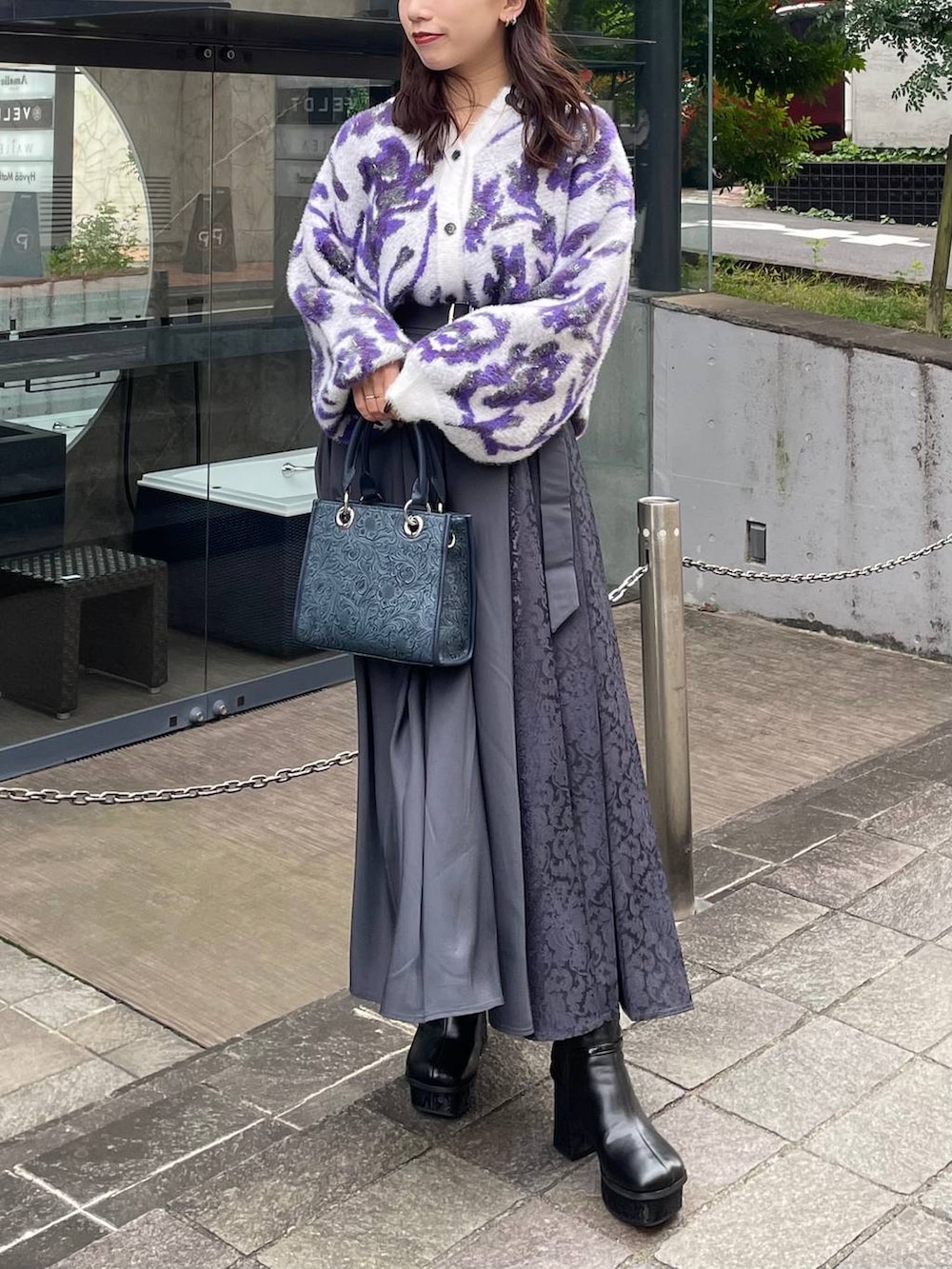 グレー系のショルダーバッグ、ホワイト系のカーディガン/ボレロ、ブラック系のブーツを着用したレディースの秋コーディネートの4枚目の写真