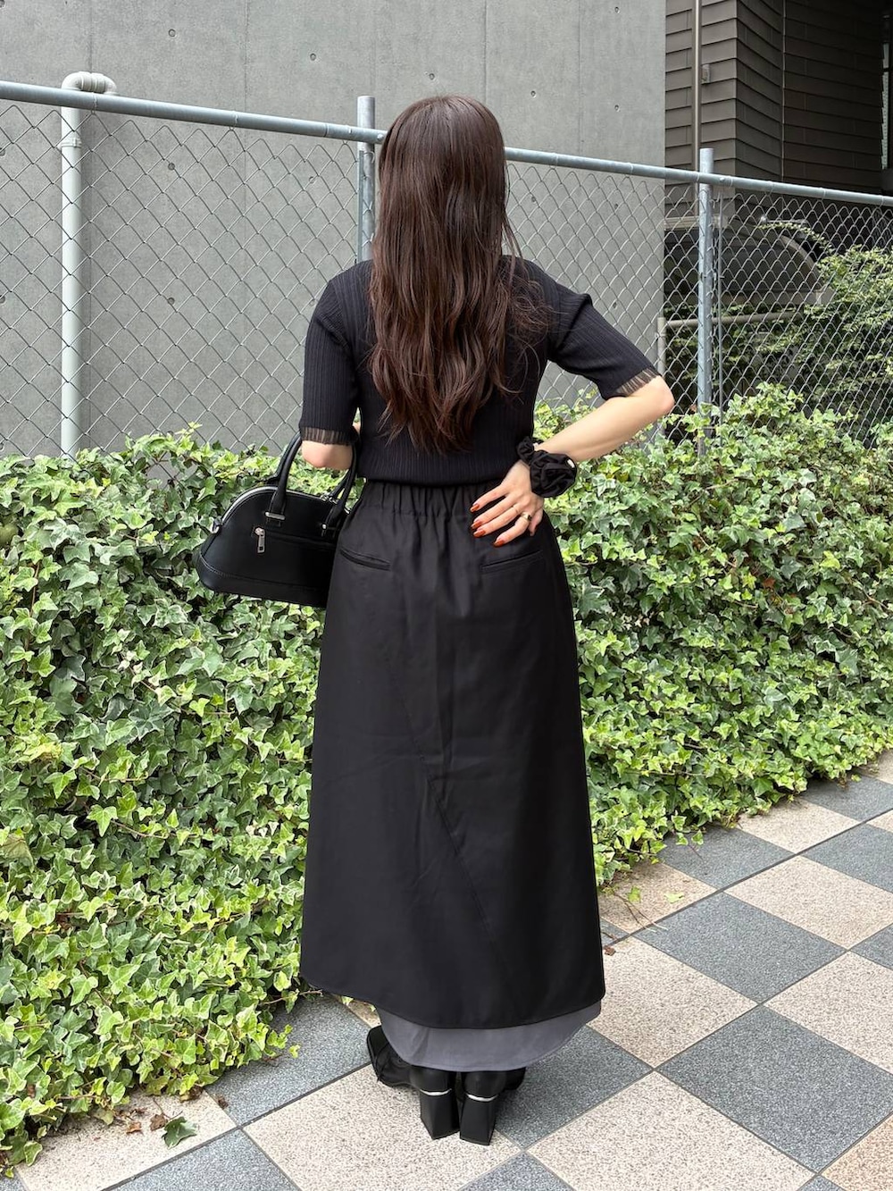 ブラック系のスカート、ブラック系のタンクトップ、ブラック系のブーツを着用したレディースの夏コーディネートの4枚目の写真
