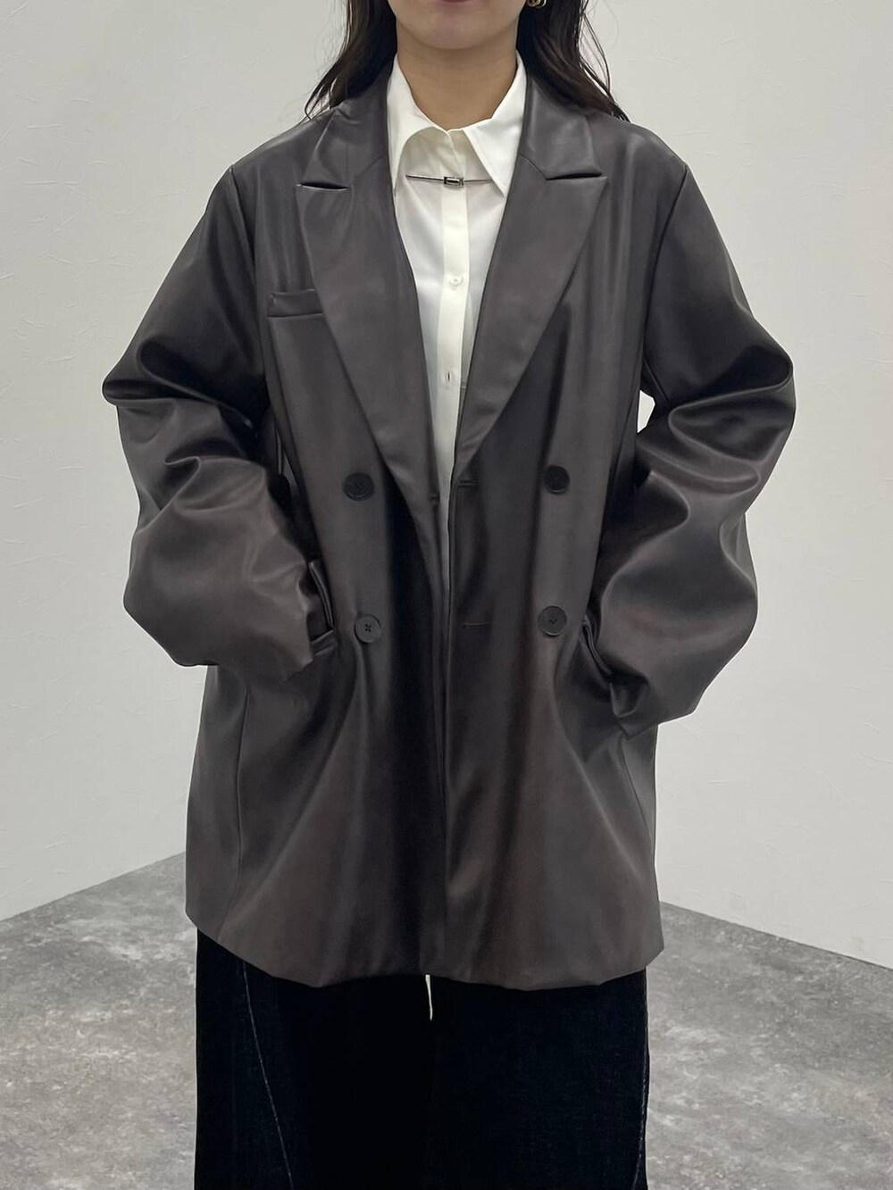 ブラウン系のテーラードジャケット、ブラック系のブーツ、ホワイト系のシャツ/ブラウスを着用したレディースの秋コーディネートの5枚目の写真