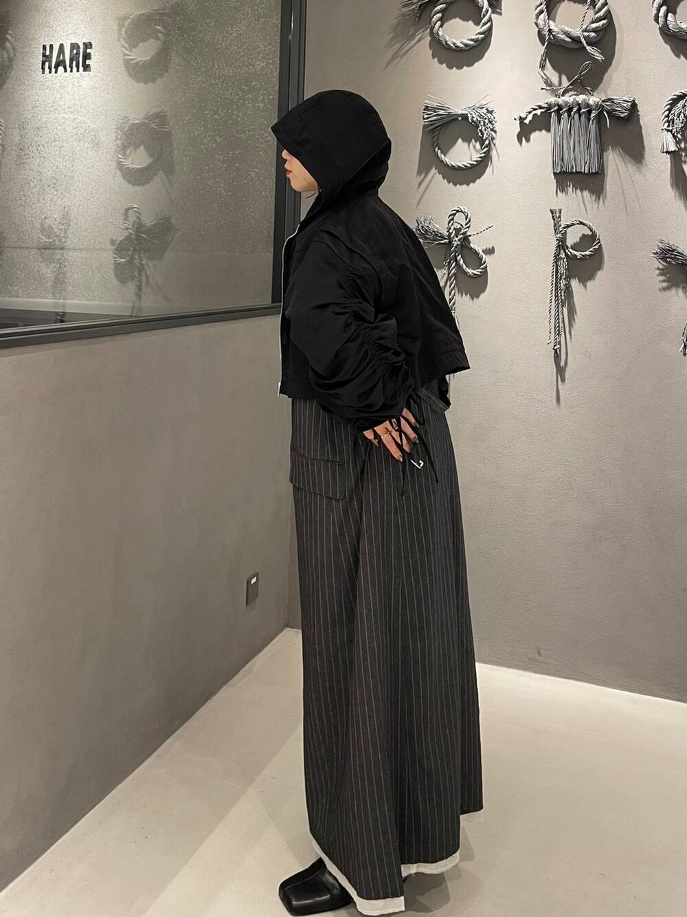 ホワイト系のタンクトップ、グレー系のワンピース、ブラック系のブーツを着用したレディースの秋コーディネートの4枚目の写真