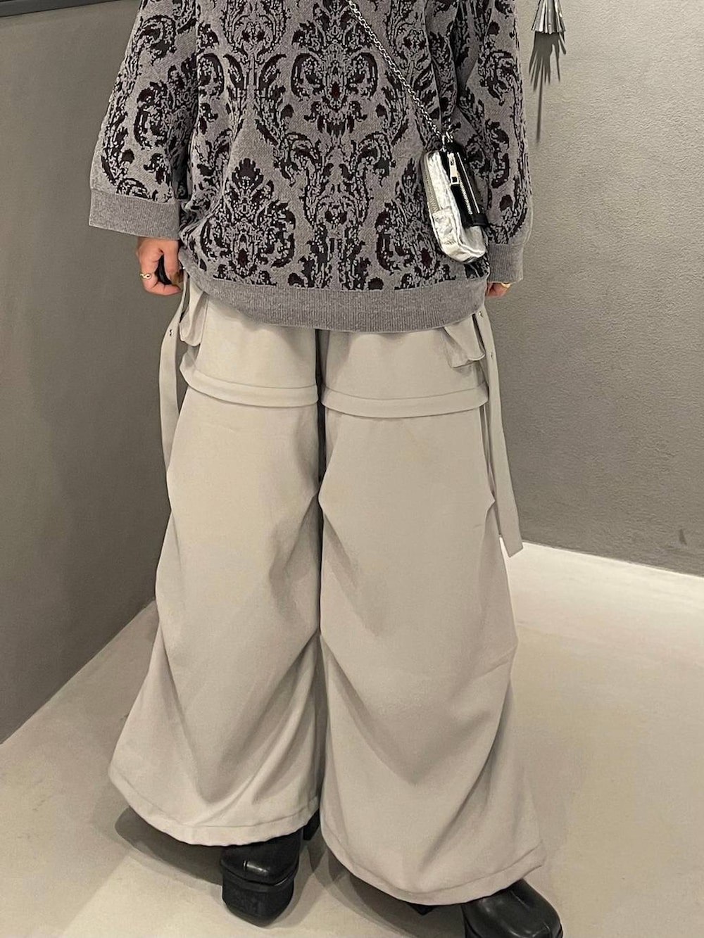 ホワイト系のカーゴパンツ、ブラック系のブーツ、グレー系のニット/セーターを着用したレディースの冬コーディネートの5枚目の写真