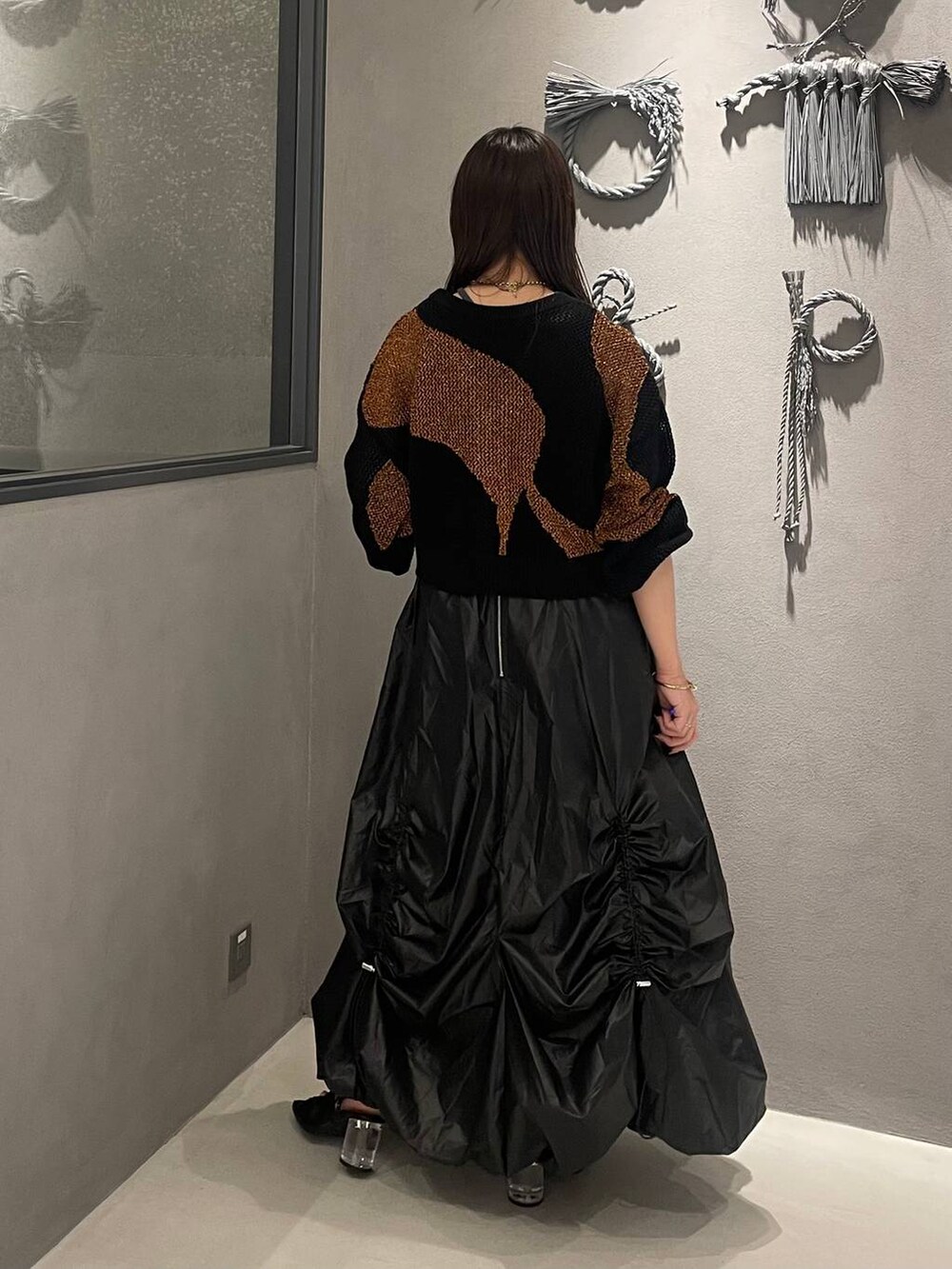 ブラック系のサンダル、オレンジ系のカーディガン/ボレロ、グレー系のタンクトップを着用したレディースの夏コーディネートの3枚目の写真