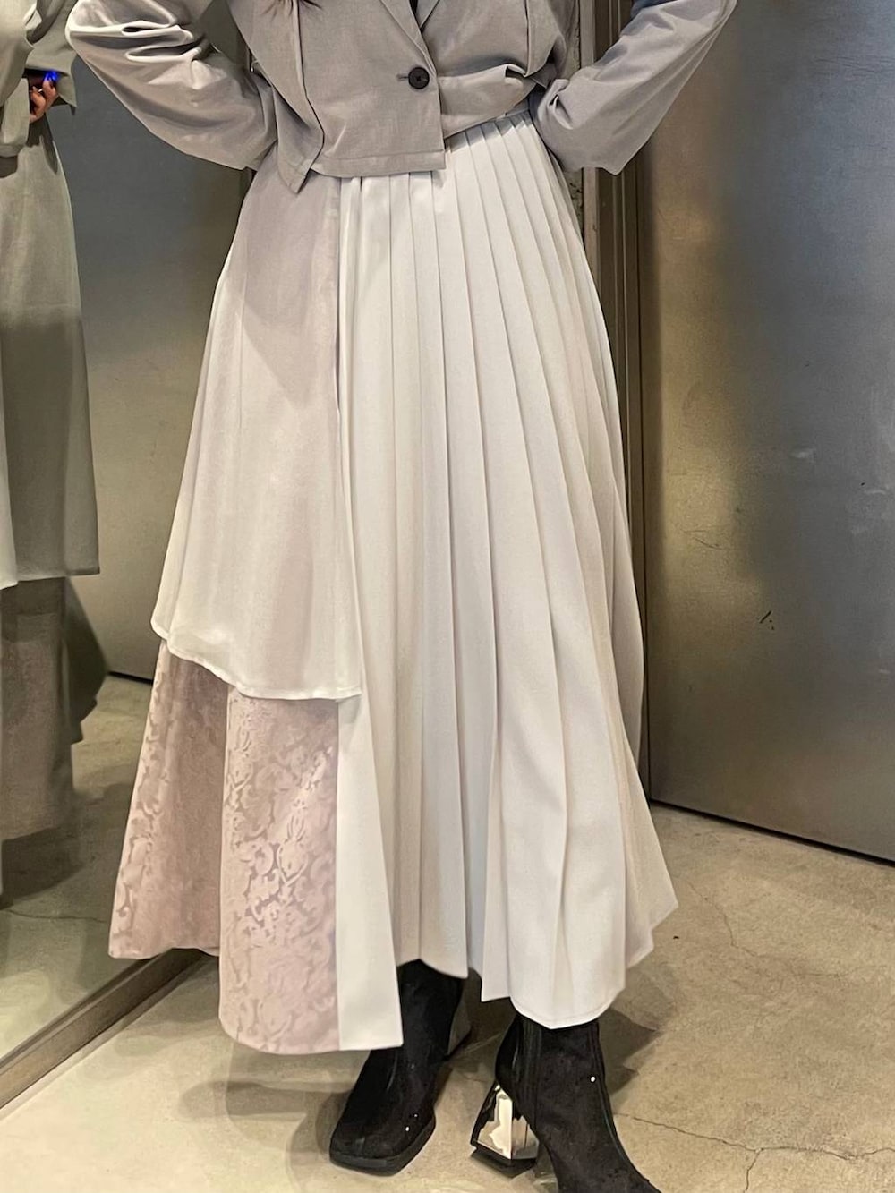 ブラック系のブーツ、グレー系のスカート、グレー系のテーラードジャケットを着用したレディースの春コーディネートの4枚目の写真