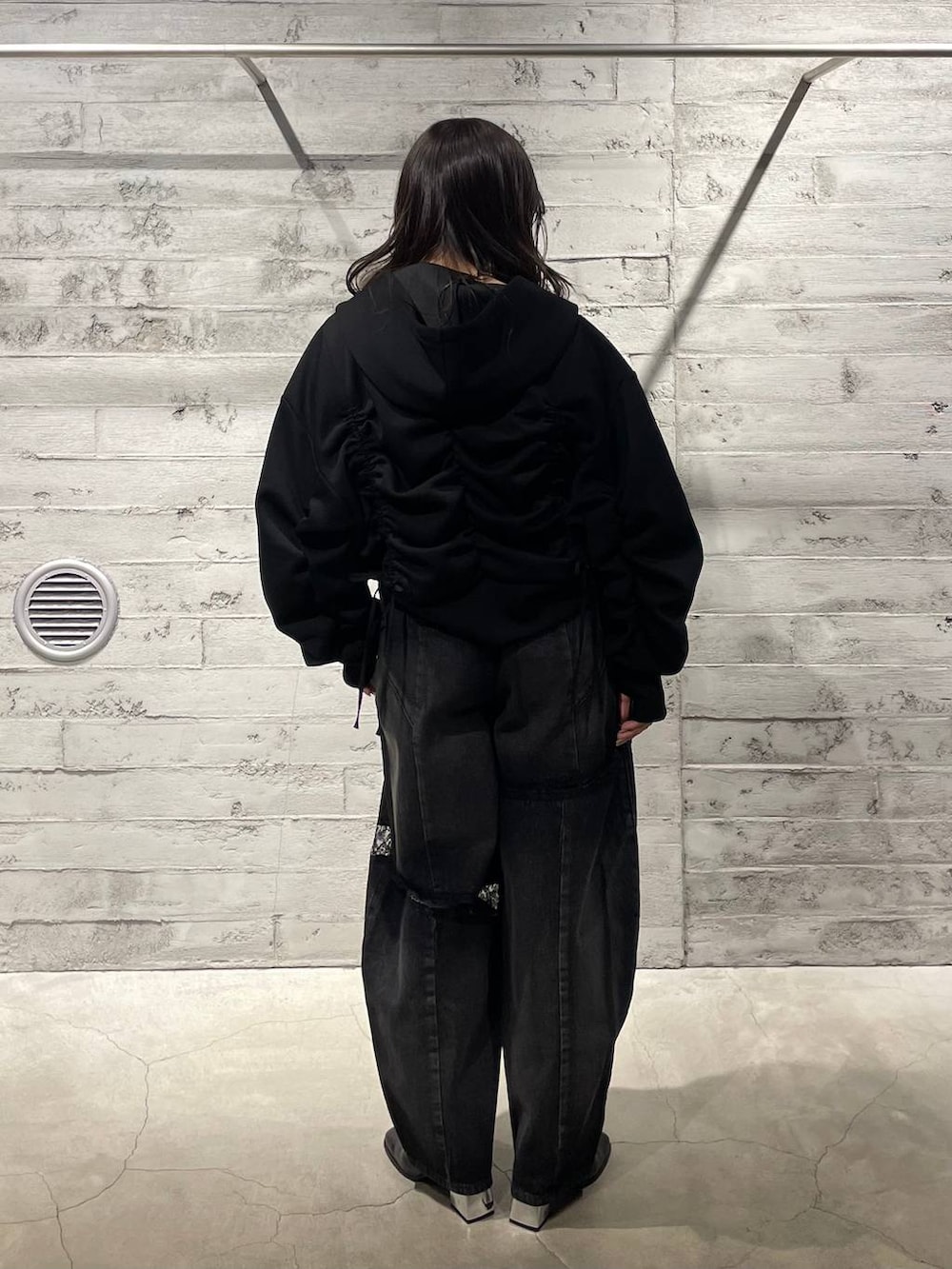 ブラック系のブーツ、ブラック系のデニムパンツ、ブラック系のパーカーを着用したレディースの冬コーディネートの3枚目の写真