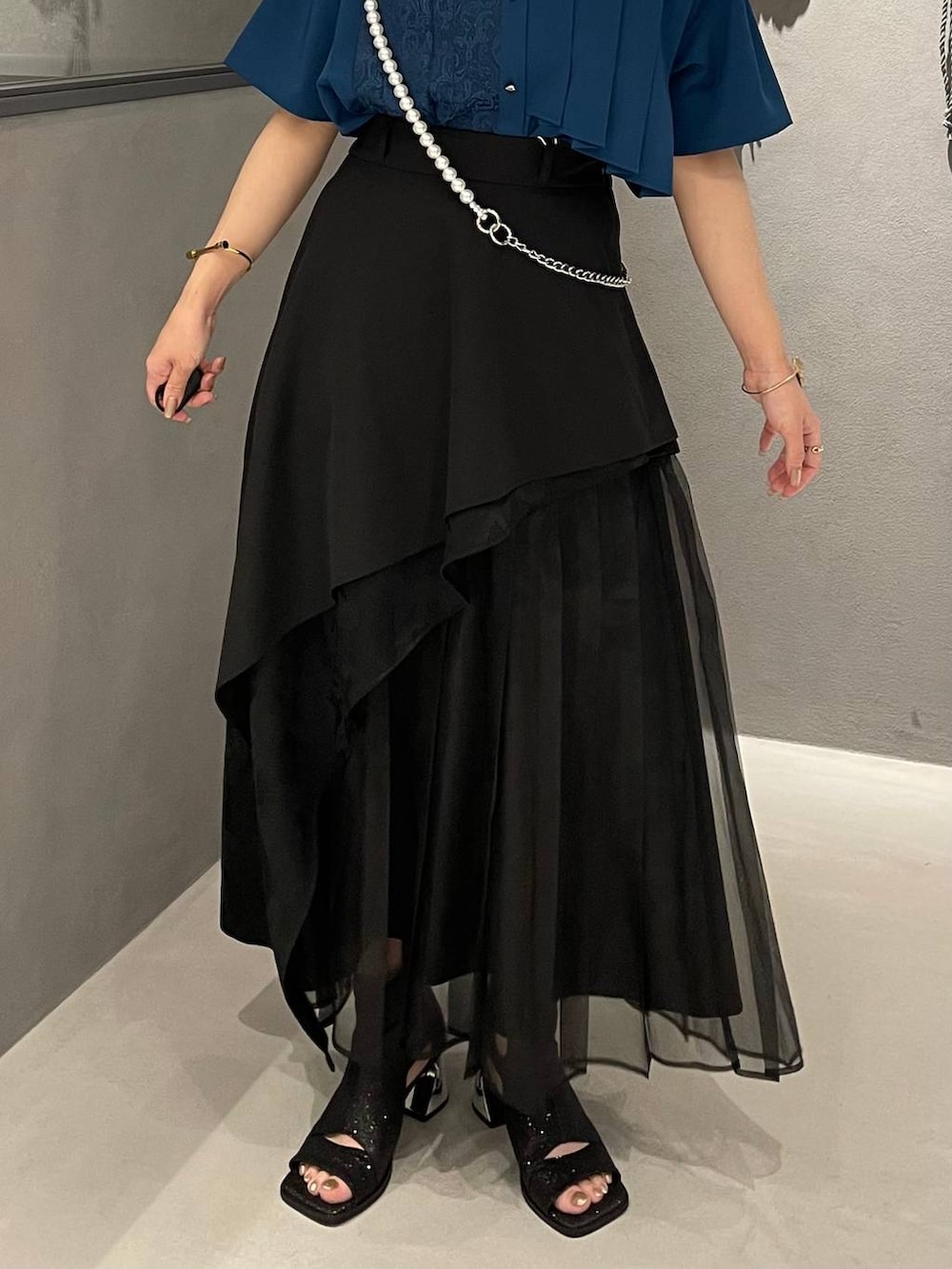 ブルー系のシャツ/ブラウス、ブラック系のスカート、ブラック系のサンダルを着用したレディースの春コーディネートの5枚目の写真